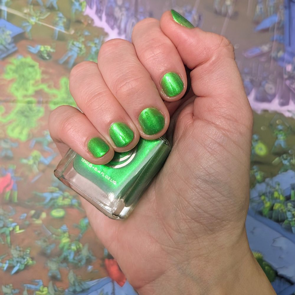 The poster's hand holding a bottle of nail polish. The poster's hand is angled so their fingernails are easy to see. The poster's nails are painted bright green. 