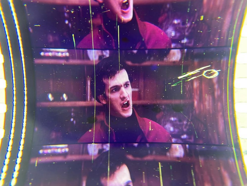 A 35mm frame from the movie "Christine," showing the changeover cue used in projection, photographed with a jeweler's loupe. The image is of Arnie Cunningham (played by Keith Gordon), looking angry and disgusted.