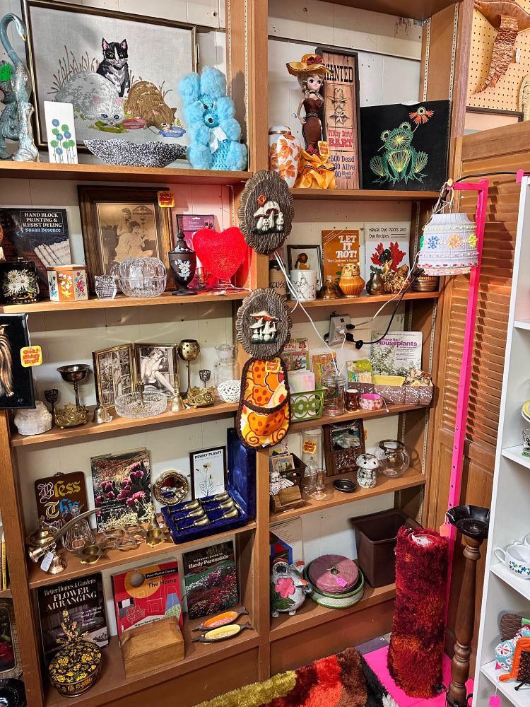 The corner of an antique shop booth, filled with vintage art and tchotchkes