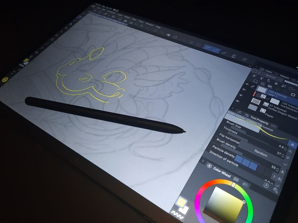 Quick photo shot of me working on a digital art illustration on a screened tablet. Linework of a coffee dragon.