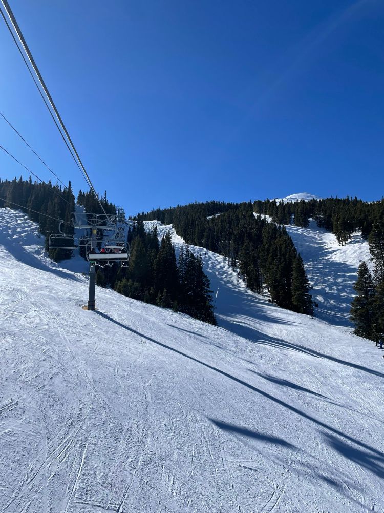 photo from chair lift of more ski runs, covered in moguls