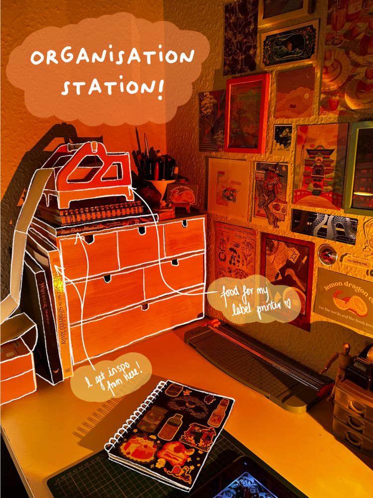A photo of a desk with drawers, art prints and a sketchbook. Caption says: Organisation Station!