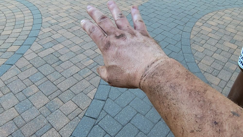 Hand and arm covered in dirt