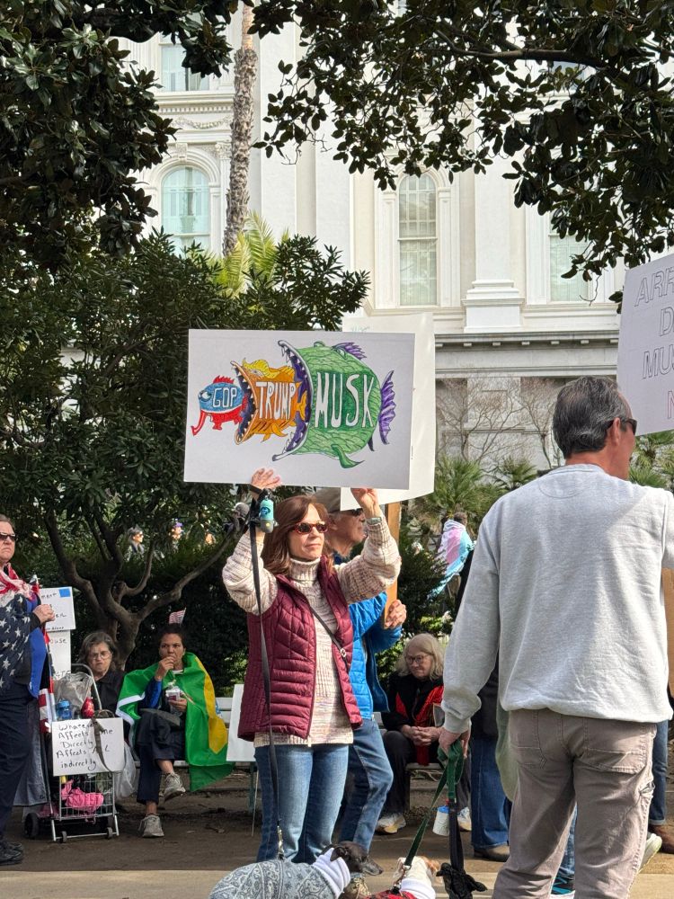 Poster with GOP depicted as a fish being eaten by a larger fish “Trump” being eaten by a larger fish “Musk” 