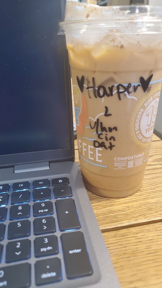 Latte to right of laptop on wooden table top