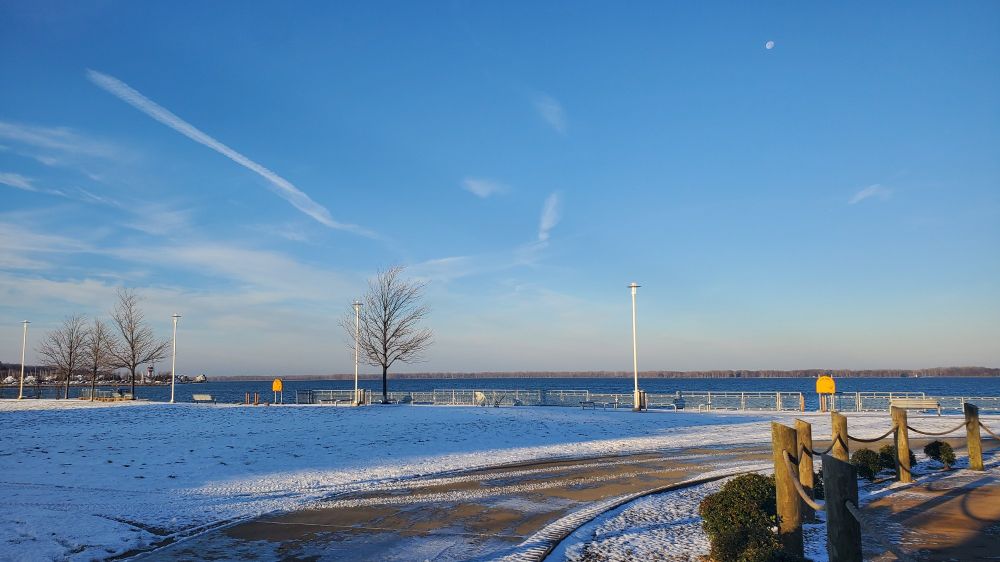Snow covered landscape with water and island in background