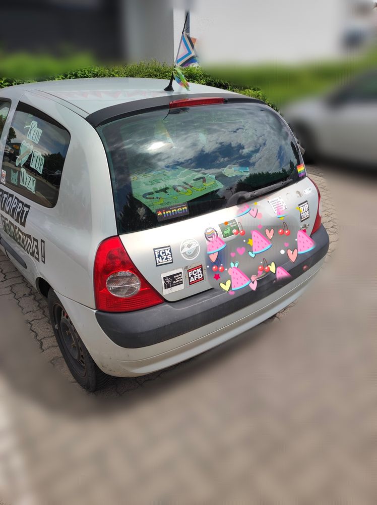 Auto von hinten mit Stickern; Antifa, Gegen Rechts, FCK NZS uvm., an der Radioantenne ist eine Regenbogenflagge und auf der Kofferraumabdeckung liegt ein Schild mit der Aufschrift: „Queer und Stolz“