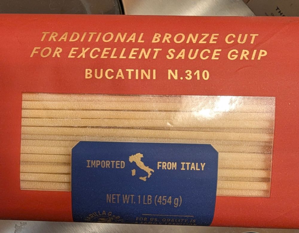 Image of a red bag of Barilla bucatini pasta. Bag has a heading stating "Traditional bronze cut for excellent sauce grip 
Bucatini N.310