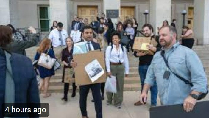 Image: Journalists garrying thier belongings out of the Pentagon after turning in their access badges.