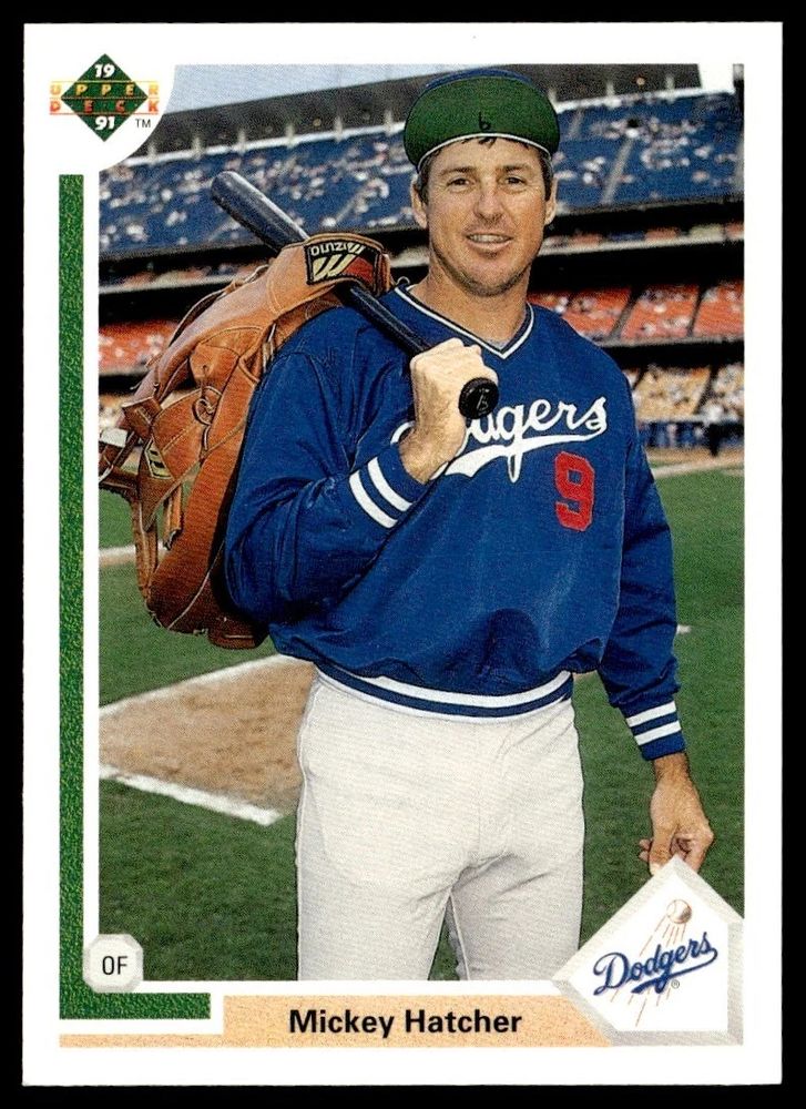 Picture of baseball card - 1991 Upper Deck #666 Mickey Hatcher - in which he has the from brim of his hat turned up while carrying a giant fielding glove over this shoulder.
