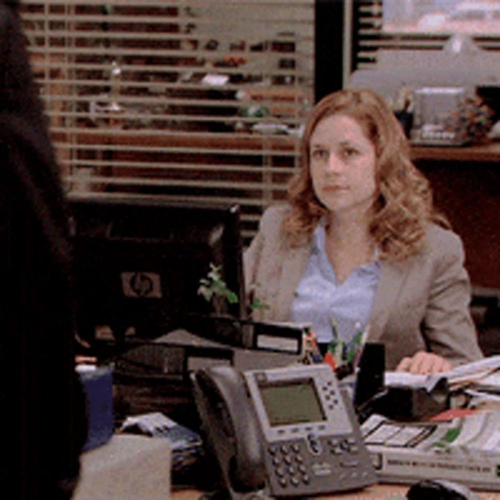 a woman sits at a desk with a hp monitor