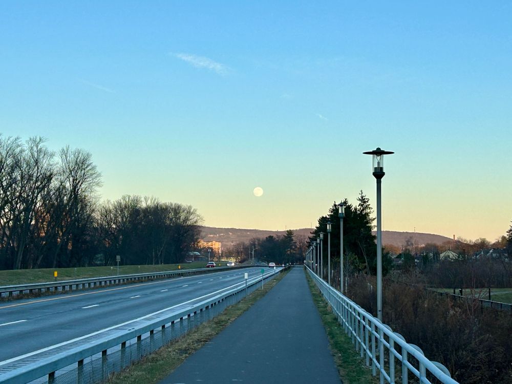 Footpath beside road, with full moon at dusk