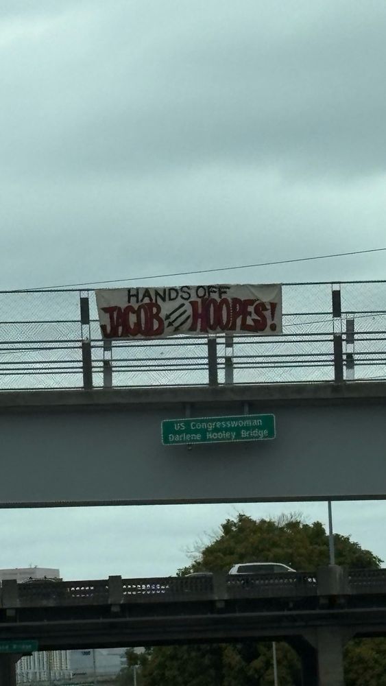Banner drop, banner says “hands off Jacob Hoopes” with an iron front in the center 