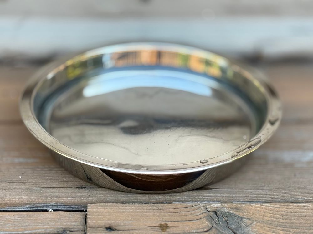 Shallow metal bowl filled with water on a deck