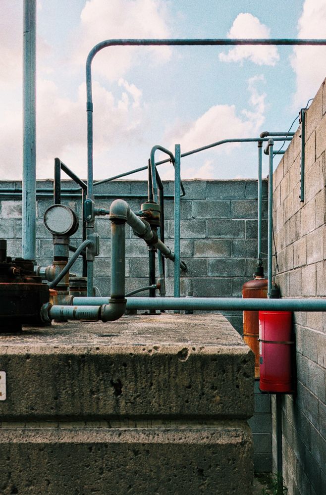 photo of the inside of an open-sky walled area filled with pipes and concrete structures 