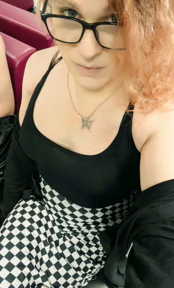 Selfie of me wearing a checkered pencil skirt with a side slit, a black tank top, and resting bitch face.