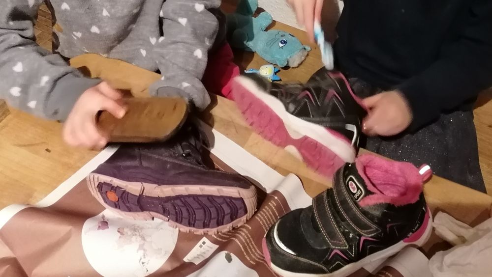 Foto von zwei paar kinderhänden, die Schuhe putzen