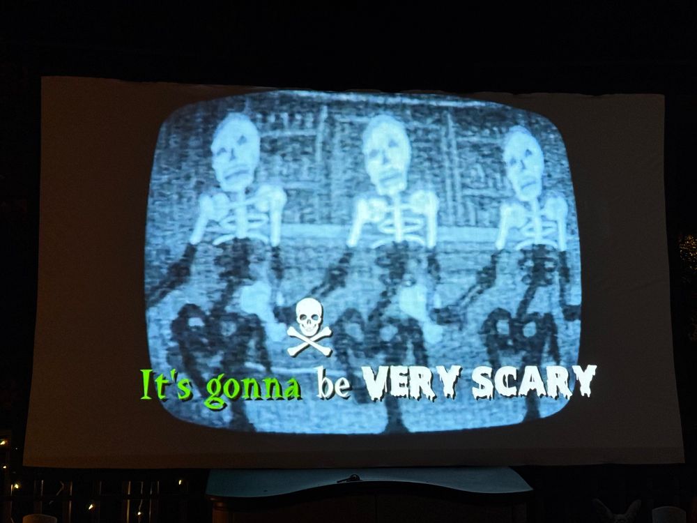 Part of the intro for the Last Drive In displaying old cartoon skeletons with text on screen “it’s gonna be very scary”
