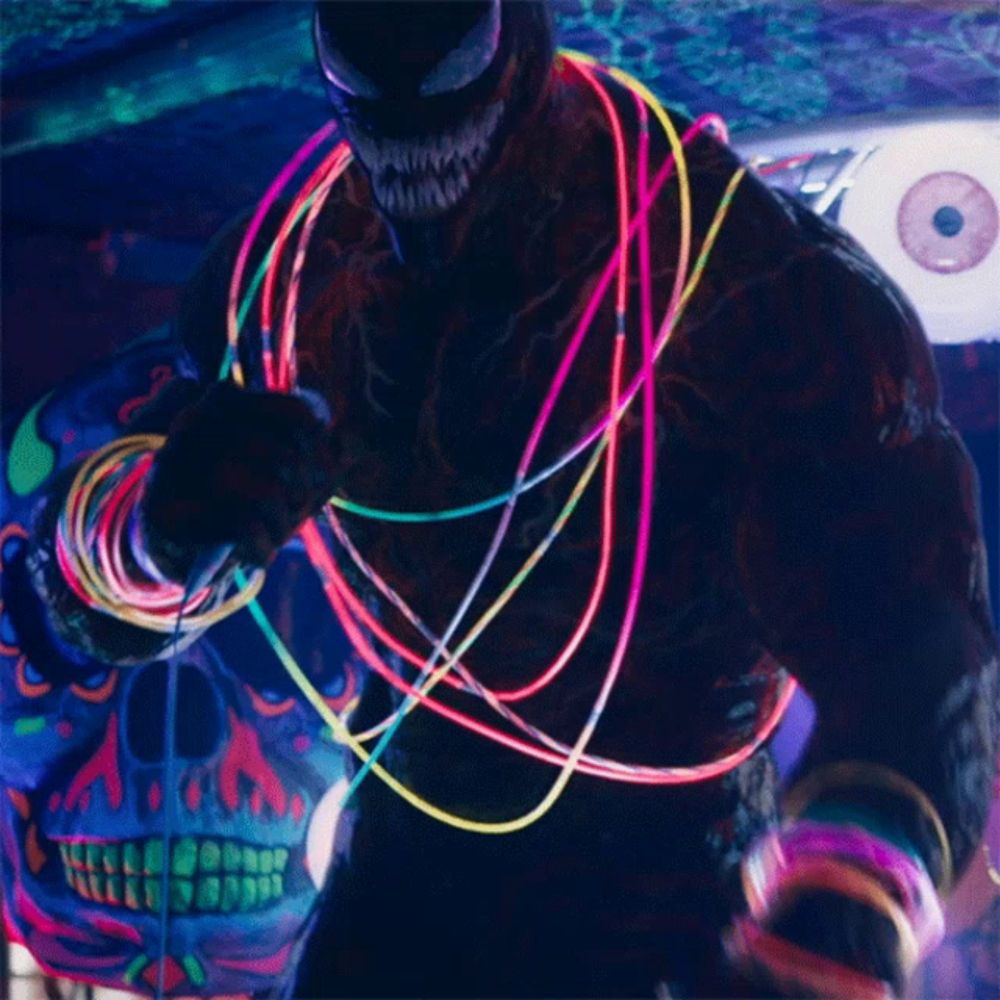 a glow in the dark venom is holding a microphone and wearing glow in the dark bracelets