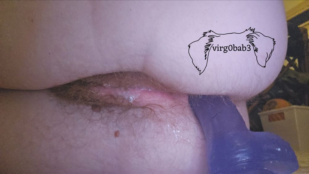 picture of my cunt and ass while im lying down on my side. my ginger bush is wet and shiny with cum. my ass is stuffed with a purple jelly dildo
