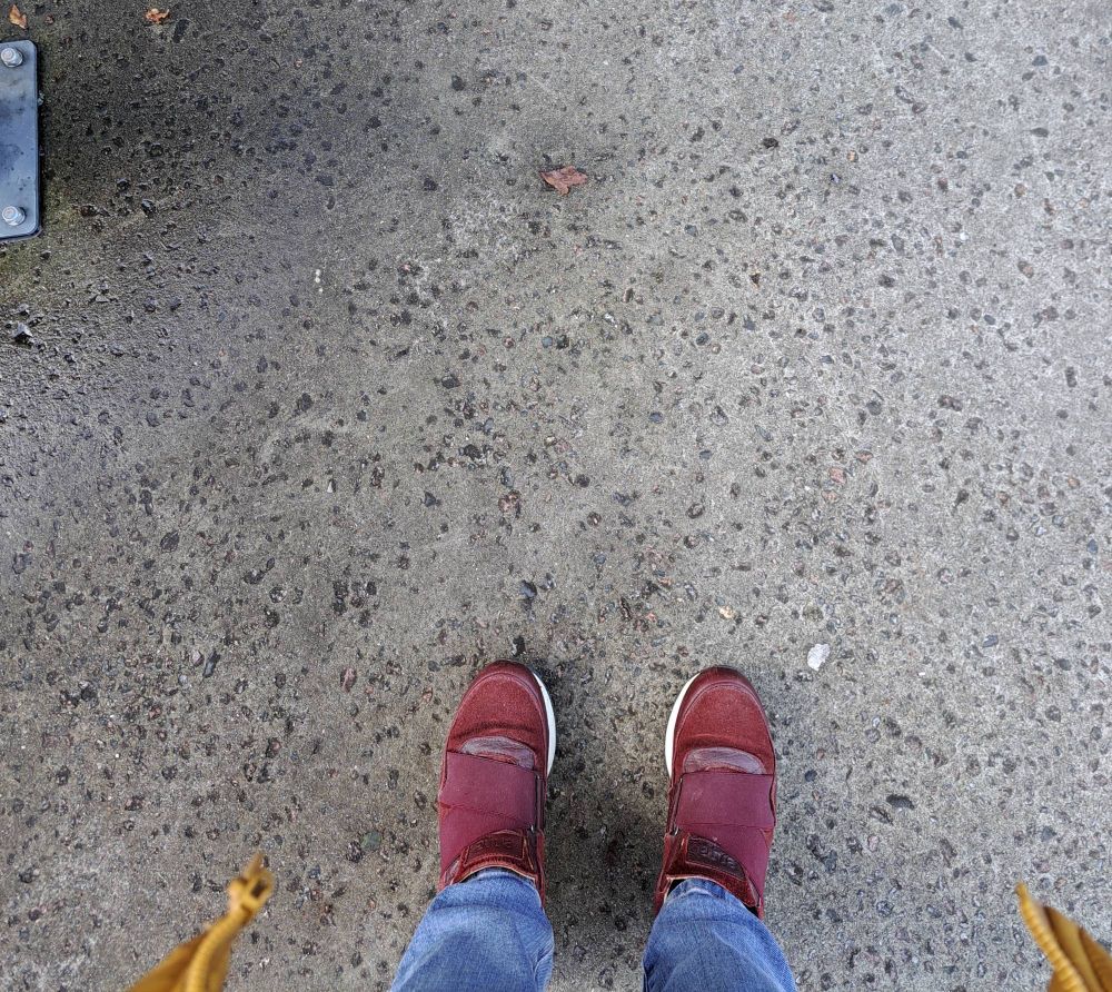 Rote Sneaker auf Betonboden.