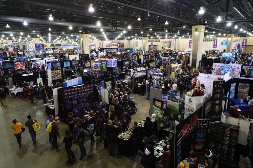 Visitors mill around an aircraft hanger-sized hall full of board game vendors. Pax Unplugged.
