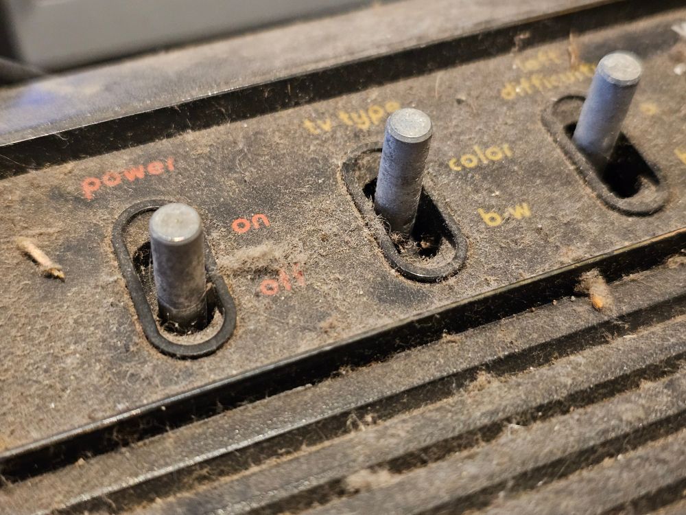 A closeup image of three dirty Atari 2600 (CX2600 "Light Sixer") switches.