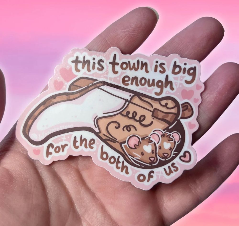A sticker of two rats in a cowboy boot w text that says “this town is big enough for the both of us”