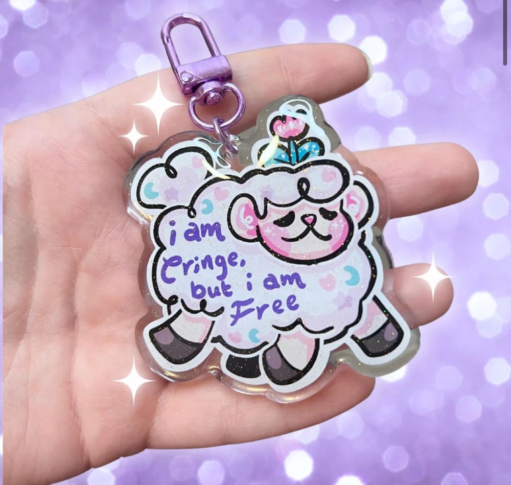 A keychain of art that features sprout the sheep galloping with text that says “I am cringe but I am free”