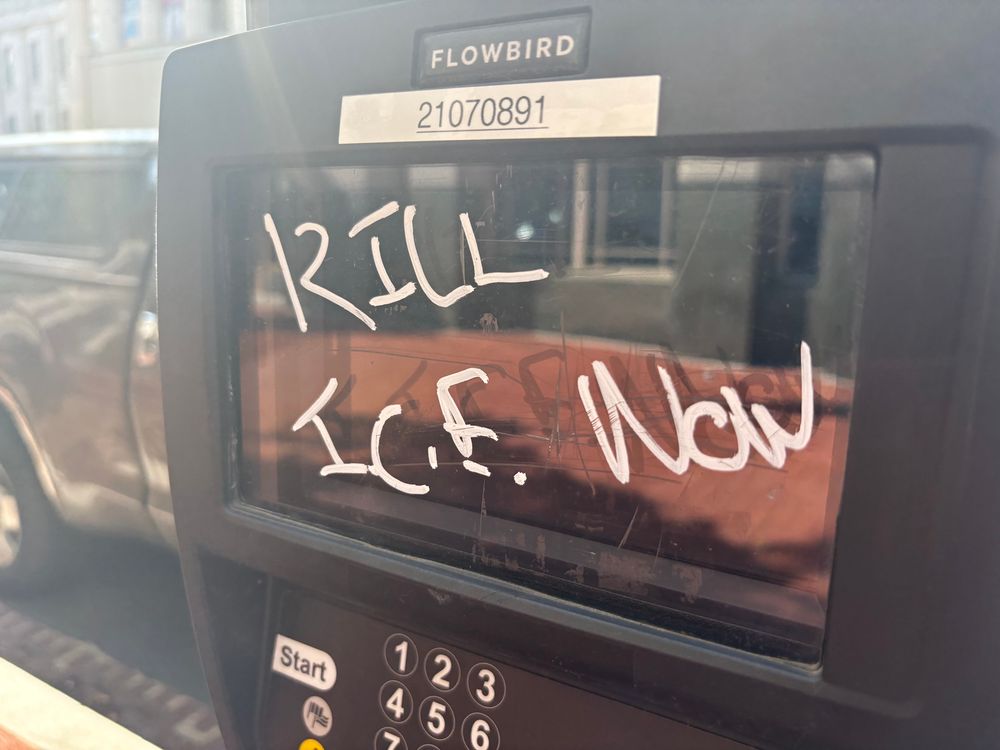 Kill ICE now, written on a parking meter. 