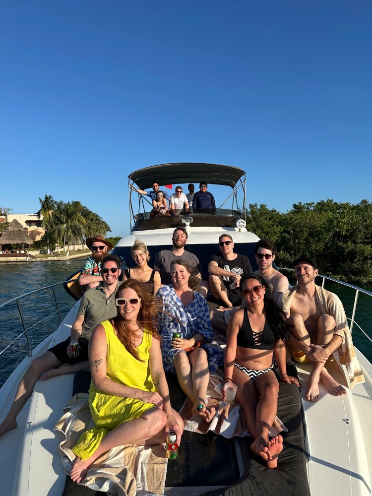 The team sitting on a boat in the ocean