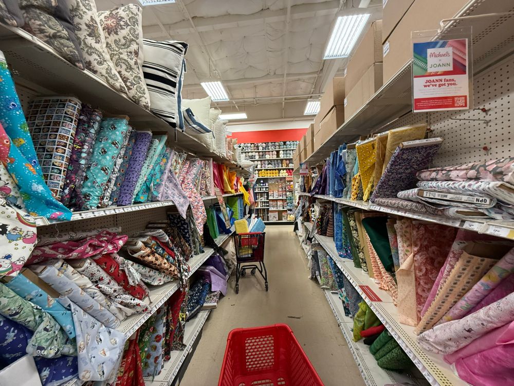 Messy rows of fabric in a Michael’s store welcoming JoAnns customers. 