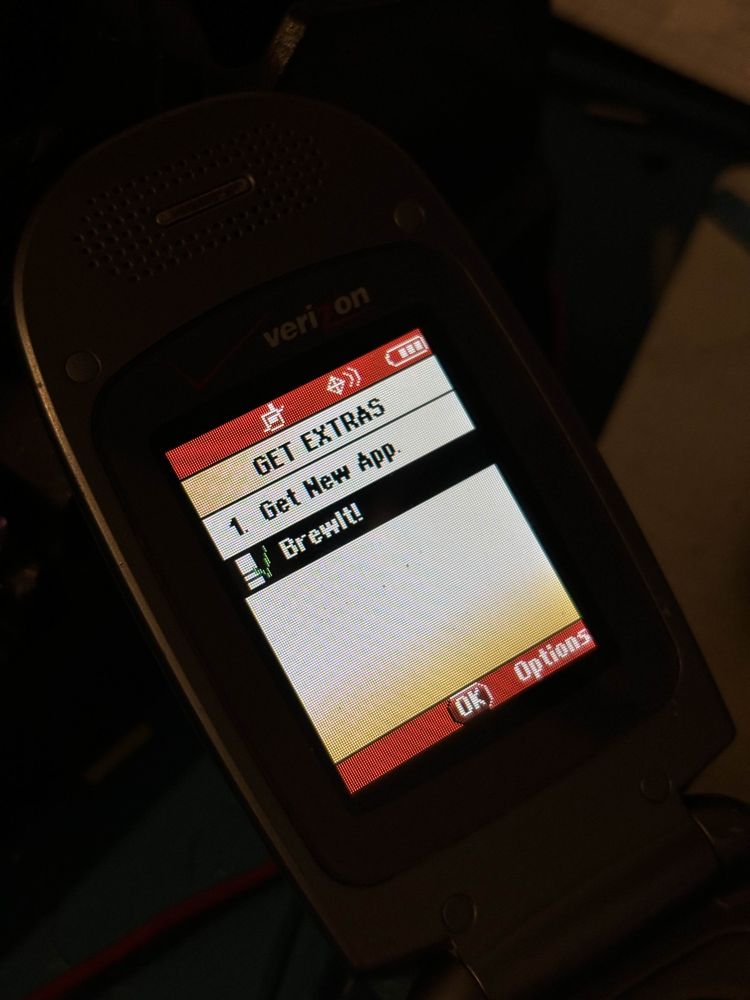 A photo of a Verizon Wireless-branded LG VX5300 on the "GET EXTRAS" screen, listing the homeBREW app "BrewIt!" from userse31: https://github.com/userse31/brewit