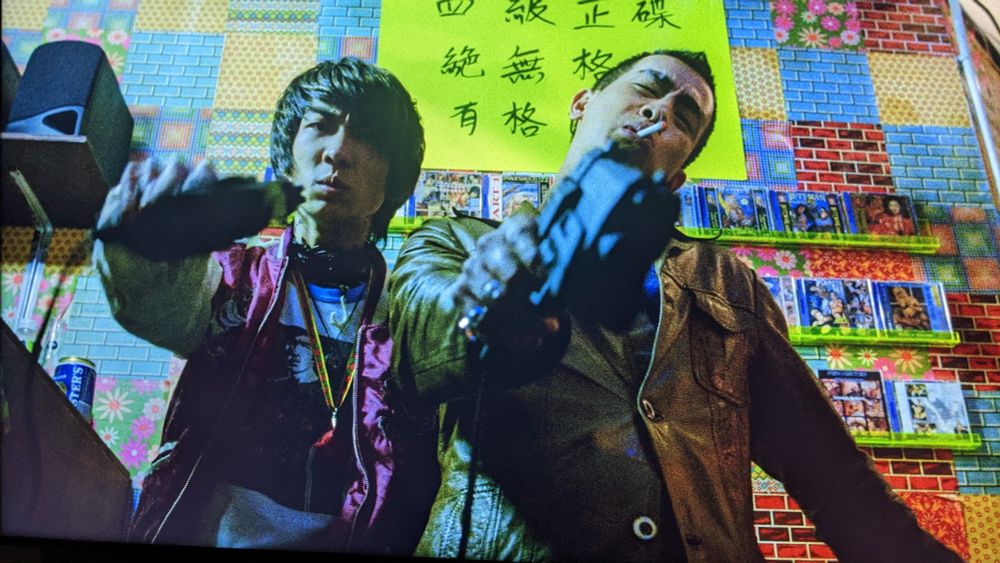 Actors Sam Lee and Jordan chan point light guns at the camera. I think they're grey market ones 