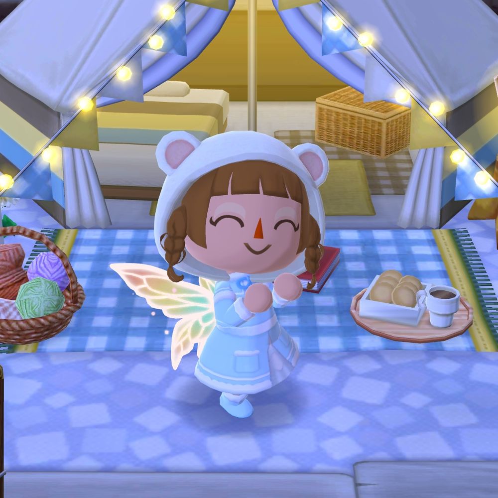 Screenshot from Animal Crossing: Pocket Camp - character is doing a cute pose in front of a white tent with fairy lights, wearing a white bear hood, light blue dress coat and rainbow fairy wings