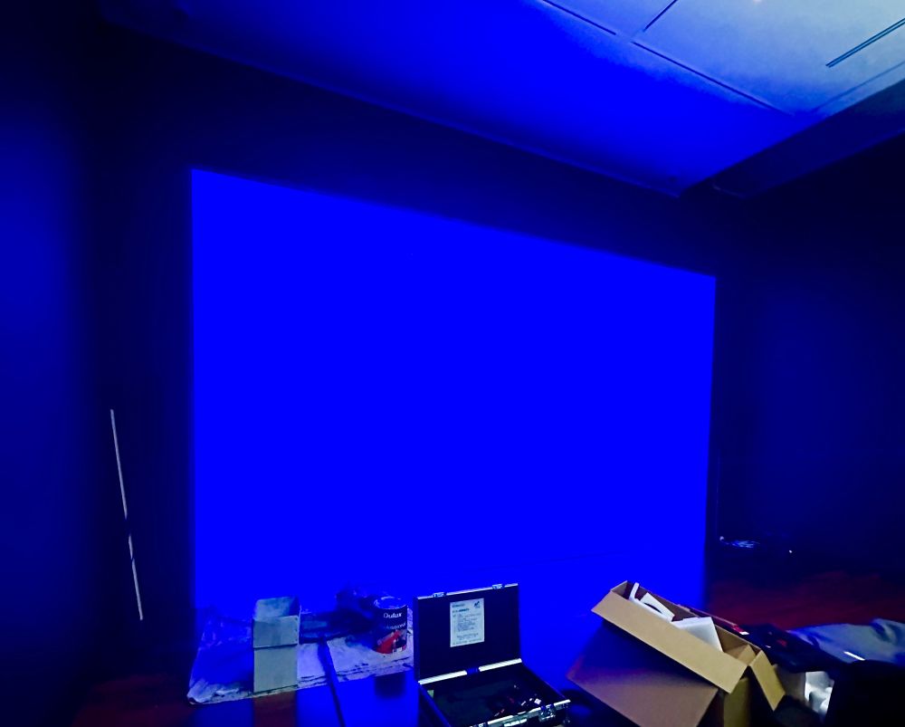 Projection on wall, the default blue of the projector, in gallery install setting.