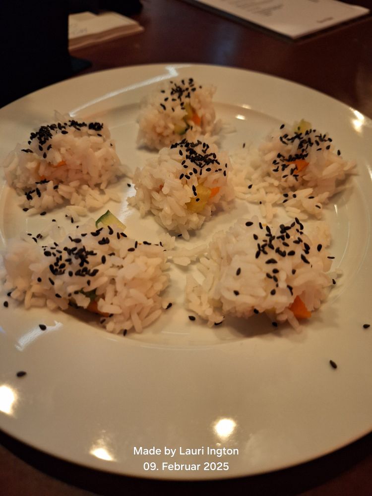 Sushi mit Gurke und Karotte garniert mit schwarzem Sesam. 
Es wurde normaler Reis verwendet, weswegen die Teilchen nicht zusammen halten.