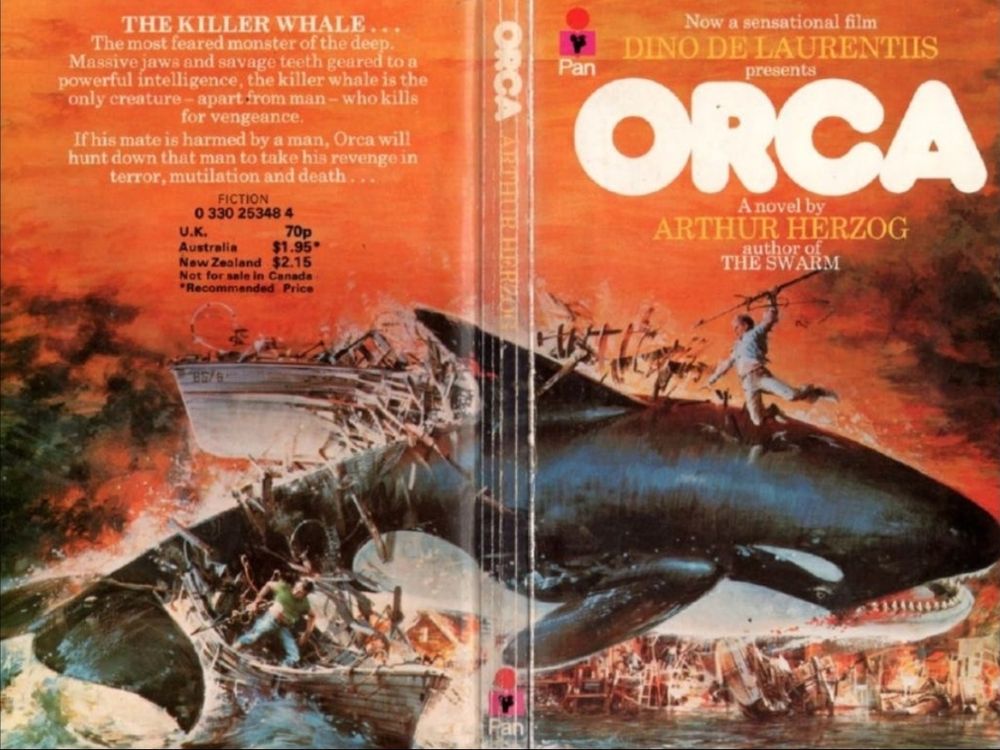 The spread cover for ORCA’s novelization tie-in by Aruthur Herzog depicting an illustration of a gigantic killer whale destroying a ship vessel as men attack the killer whale with spears and other weapons.