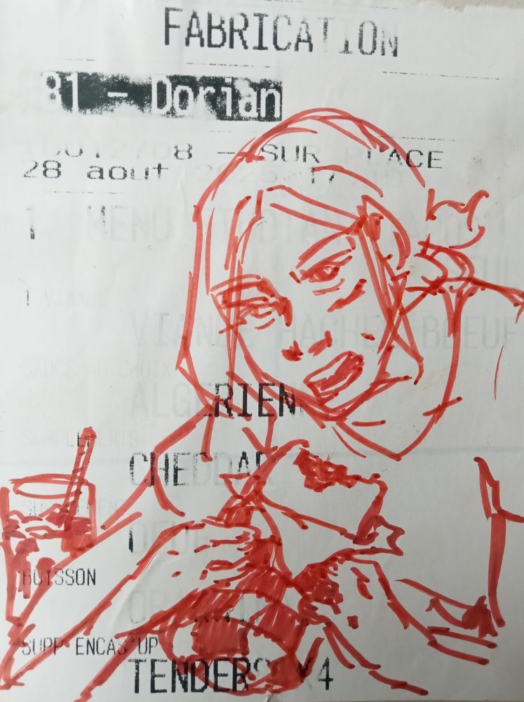 A faded restaurant receipt from a trip to Strasbourg with a red felt tip pen doodle of a girl looking at the viewer while getting ready to bite into a burrito looking thing.