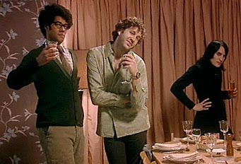 Still from IT Crowd showing Moss, Roy, and Richmond at a dinner party trying to act natural but looking anything but natural
