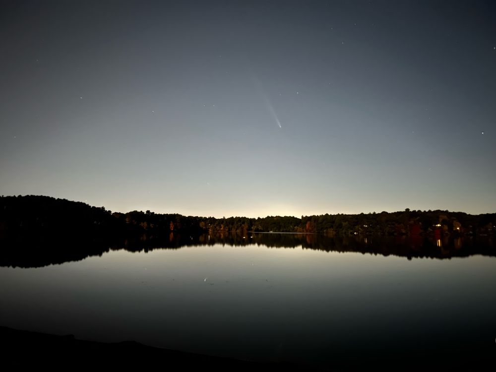 photo taken on the beach of a lake. dark, an hour after sunset about.  in the center of the picture, very faint, is a comet