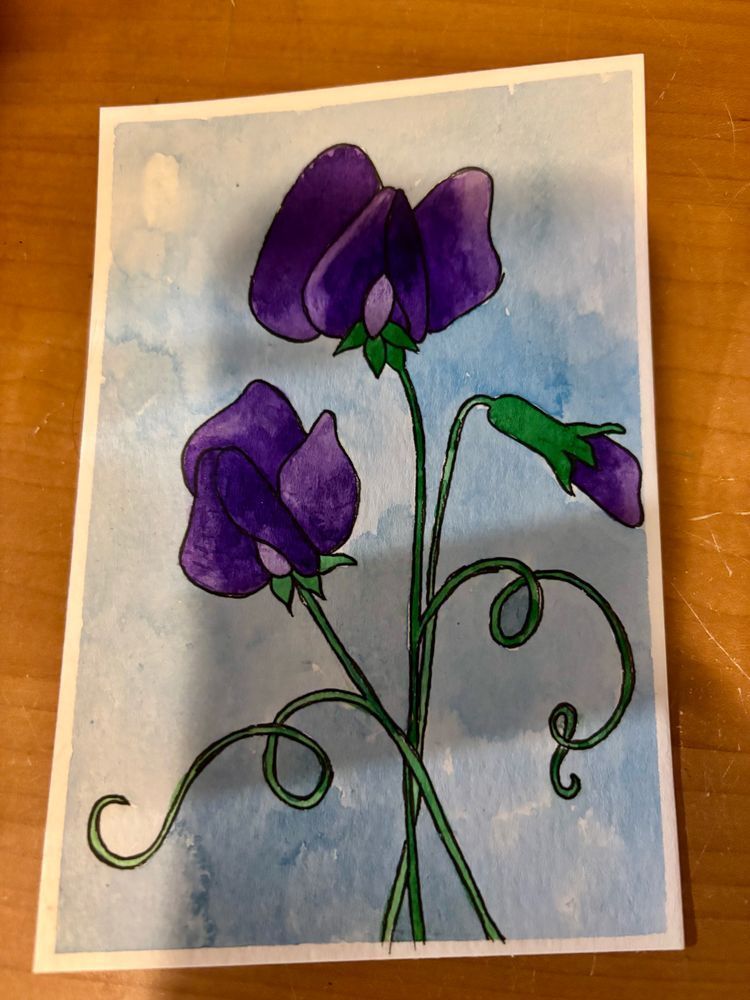 The front of a watercolor postcard. The postcard contains two open sweet pea blooms and a sweet pea bud. All of the flowers are purple. The background is a light blue.