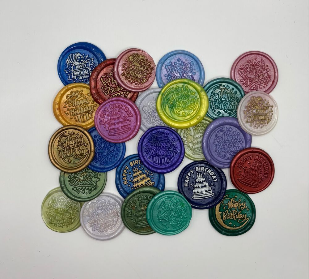 A pile of 25 assorted wax seals in different colors. Each says “happy birthday.”