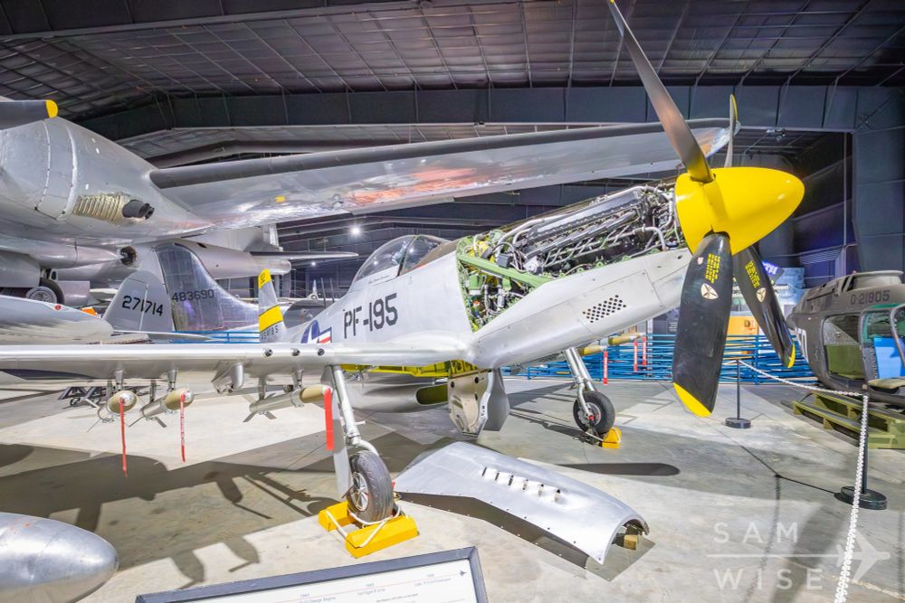A P-51H on display in a museum with its engine cover removed