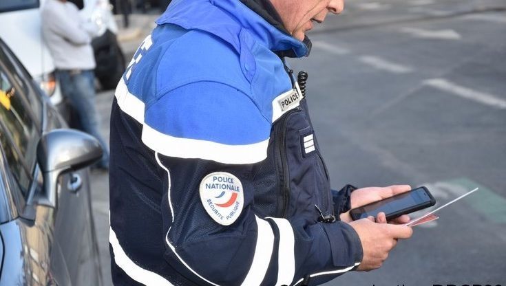 Policier écrivant un message sur un téléphone portable 