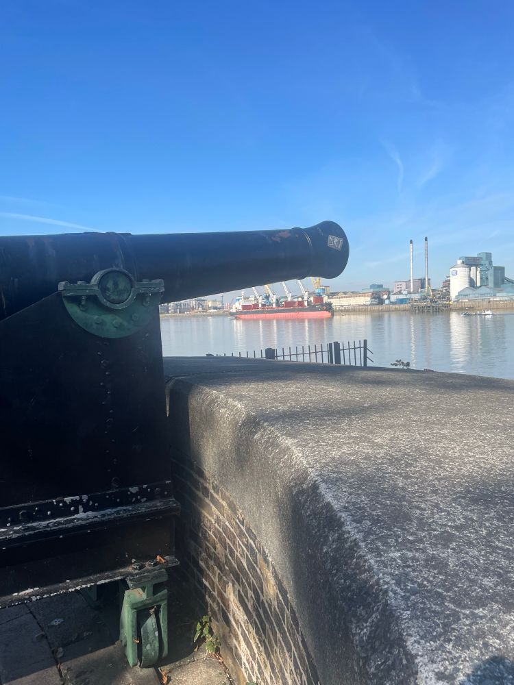 Woolwich Dockyard looking north across the Thames towards Tate & Lyle’s Silvertown refinery, with a ship discharging raw cane sugar for refining.