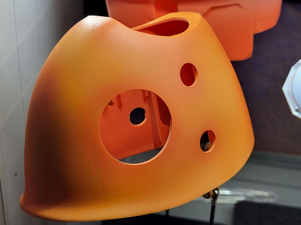 The face of magikarp, many details not yet attached. It's a bright orange, with a subtle darker shade around the eyes and the places the fins and whiskers will eventually attach.