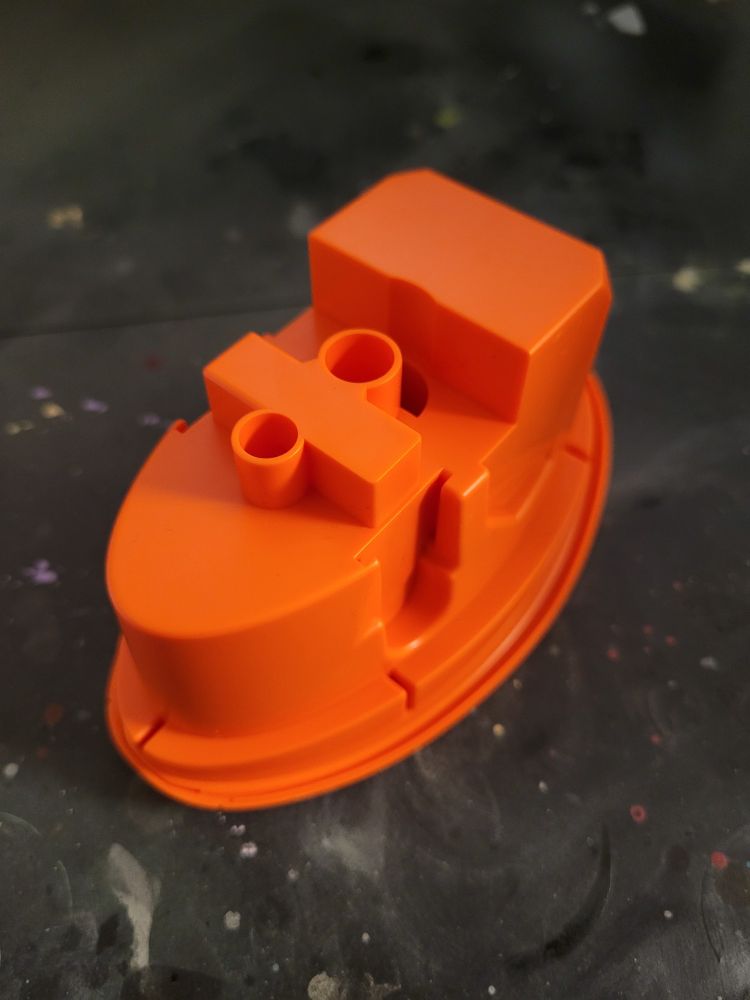 A piece of a model, a dark, flat orange color. 