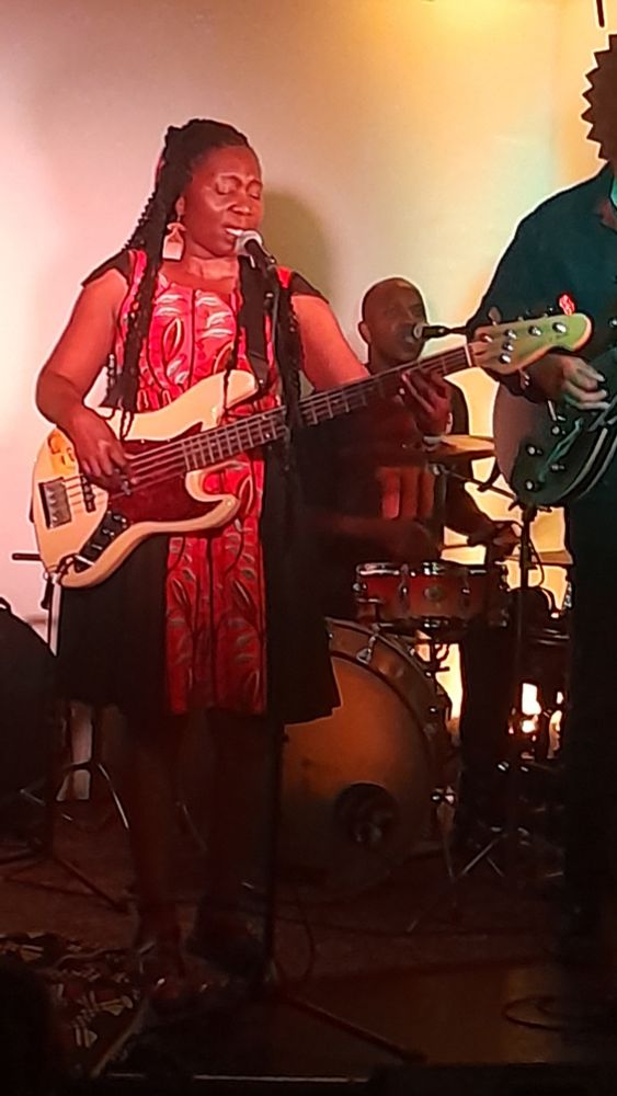 Edith Weutonga and band on stage in intimate venue.