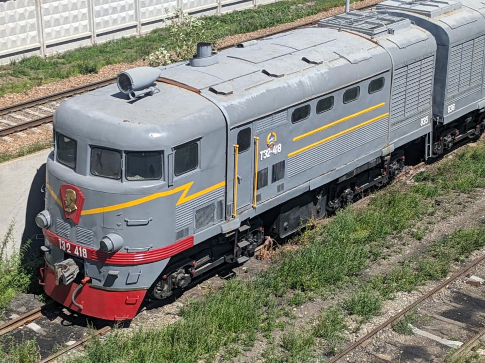 A shot of the side of an old diesel (I think) locomotive parked in a siding just to the east of Ulaanbaatar's central railway station. It's grey and red with a yellow lightning bolt stripe running around its front.
